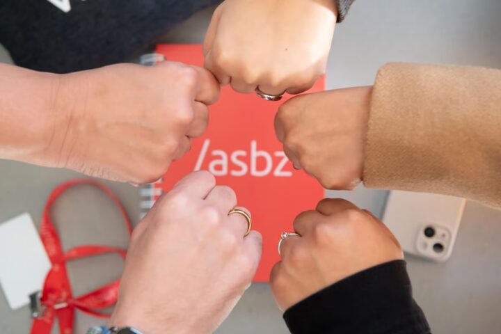 Empresa sistema B: pessoas juntando as mãos fechadas e a logo do /asbz ao centro.