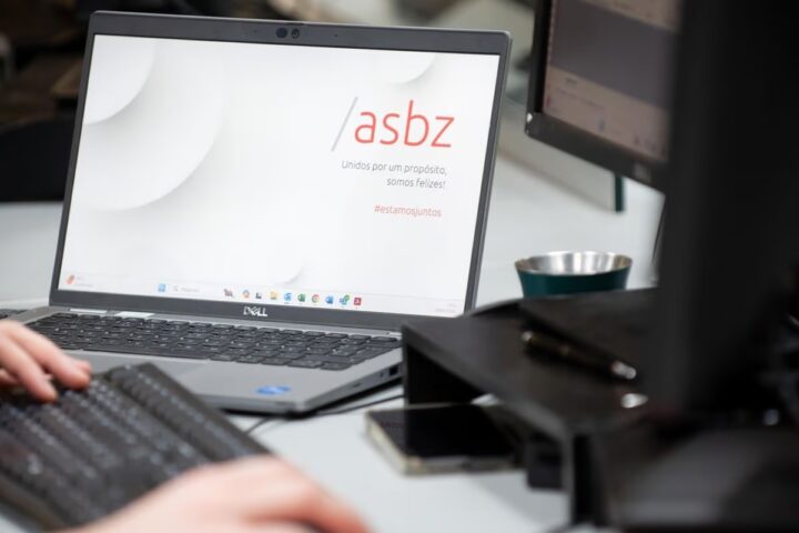 Imagem de um laptop com a tela exibindo a mensagem "Unidos por um propósito, somos felizes!", refletindo o uso da tecnologia na advocacia para promover a colaboração e eficiência no ambiente de trabalho.